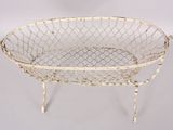 an antique white wire basket with a metal handle and legs