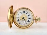 an image of a gold pocket watch with roman numerals on the face
