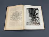 an open book with a picture of a city on it