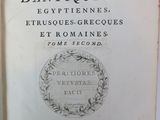 an old book with a picture of a wreath on the cover