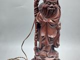 une image représentant la statue d'un homme tenant une lampe posée sur une table