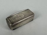 an antique silver cigarette case on a white surface