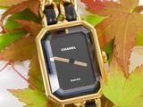 a black and gold watch with a chain around it