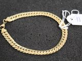 gros plan d'un bracelet en or portant une étiquette de prix