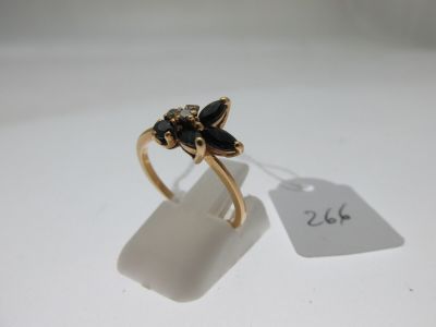 une photo d'une bague en or sertie de pierres noires, avec une étiquette indiquant le prix