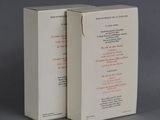 two white boxes with red writing sit side by side on a gray surface