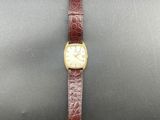 a watch with a brown leather strap and a white face