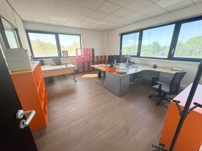une salle où se trouvent de nombreux bureaux et chaises