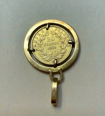 une pièce d'or au centre d'un pendentif circulaire