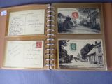 an open book with a picture of a street and a postcard on it