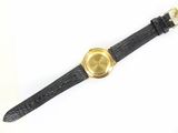 an image of a black watch with a gold face on a white surface