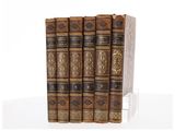 un coffret de trois livres à couverture marron et bordures dorées