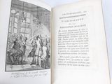 an open book with a picture of people in a room