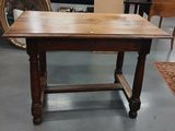 une table avec un plateau en bois, dans une pièce