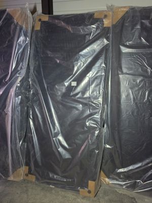 three black plastic bags sitting on top of pallets in a warehouse