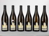 six bottles of wine are lined up on a table