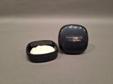 a small container of cream next to a small container of cream