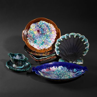 several pieces of pottery are displayed on a black surface