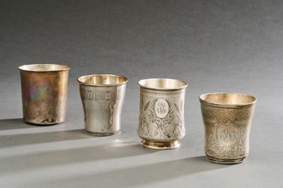 trois tasses en argent posées sur une table, l'une à côté de l'autre