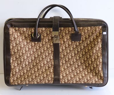un sac marron et noir posé sur une surface blanche
