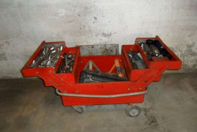 un chariot à outils rouge contenant des outils, dans un garage