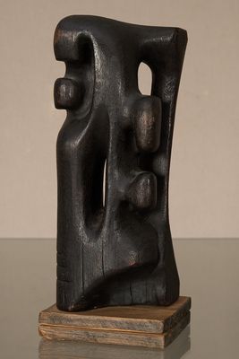 une photo représentant une sculpture noire posée sur une table en verre