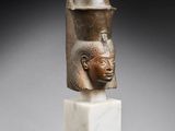 an egyptian bronze head of a pharaoh on a marble base