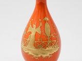 un vase orange orné d'un motif doré