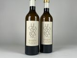 two bottles of wine sitting next to each other on a table
