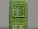 a small green bottle with chinese writing on it