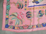 a pink scarf with a picture of a bird and palm trees on it