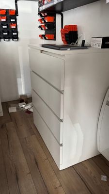 an image of a kitchen with white cabinets and wood flooring