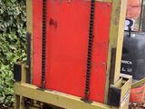 a red and yellow forklift sitting in the middle of a garden