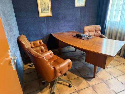 a desk with a chair and a computer on it in a room