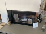 une cheminée avec un verre de vin sur la table