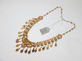 gros plan d'un collier en or sur une surface blanche