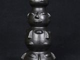 a close up of a sculpture of three faces on top of each other