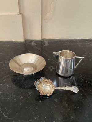 une tasse et une soucoupe argentées posées sur un plan de travail noir