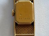une image d'un gros plan d'une montre-bracelet sur une surface blanche