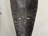 pair of wooden masks hanging on a wall in a room