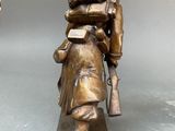 bronze statue of a man carrying a child on his back