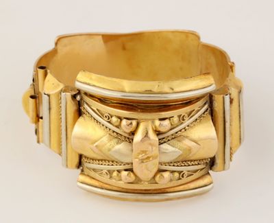 une image d'un gros plan d'un bracelet en or sur une surface blanche