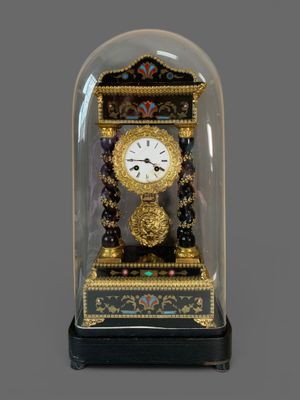 a small clock under a glass dome on a table