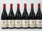 six bottles of red wine lined up in a row on a white surface