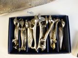 un tas de cuillères en argent dans une boîte posée sur une table