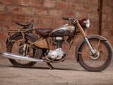a old motorcycle that is parked in front of a brick wall