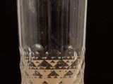 a glass of water sitting on a table with a black background