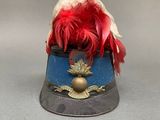 a small hat with a red feather on top of it