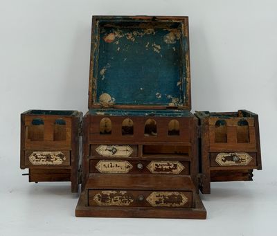 un petit coffre en bois à trois tiroirs, surmonté d'un miroir