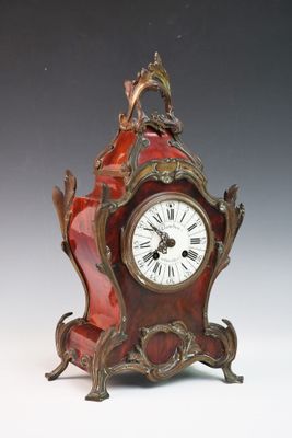 une horloge rouge surmontée d'un oiseau